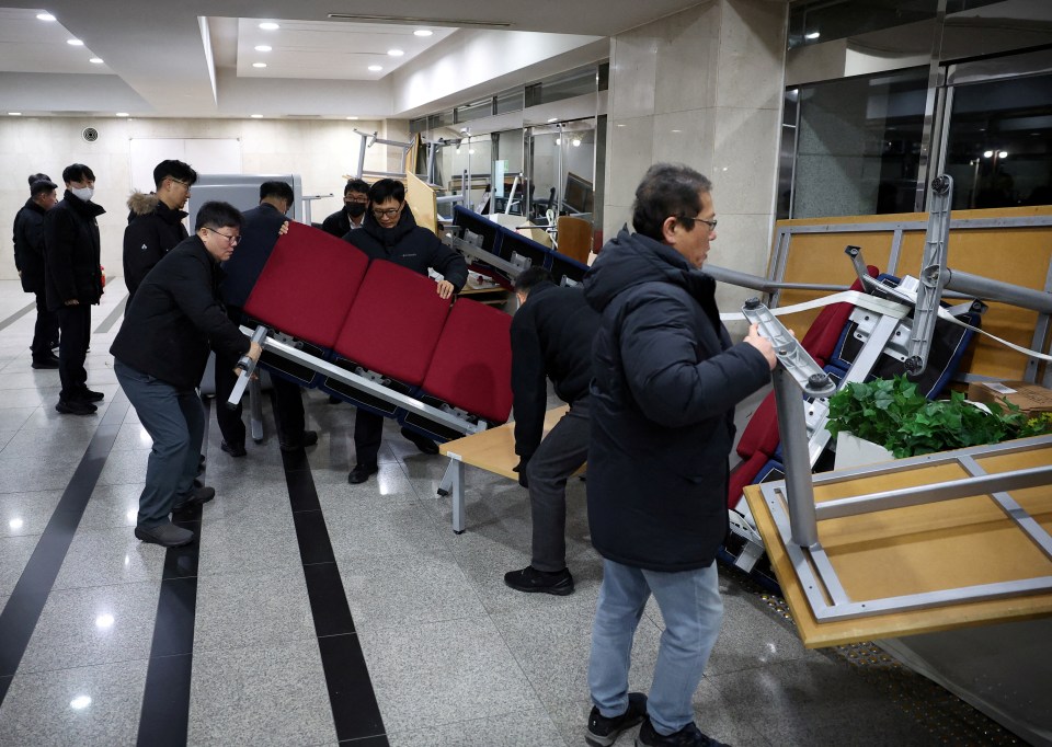 Officials remove the furniture barricades from the doors of the National Assembly building