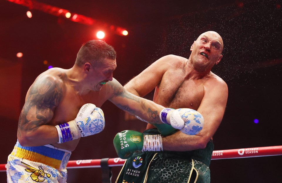 Oleksandr Usyk punches Tyson Fury during a boxing match.