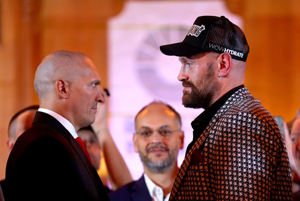 Oleksandr Usyk and Tyson Fury face off at a press conference.