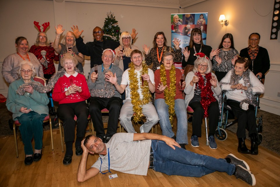 Group photo of seniors and actors at a Christmas party.