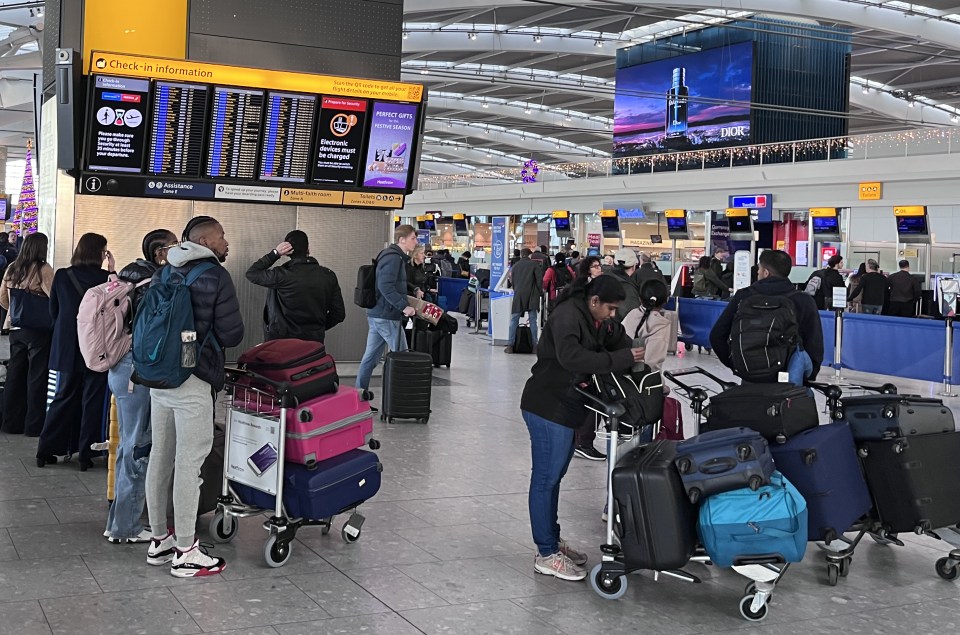 Passengers queue at Heathrow Airport terminal five