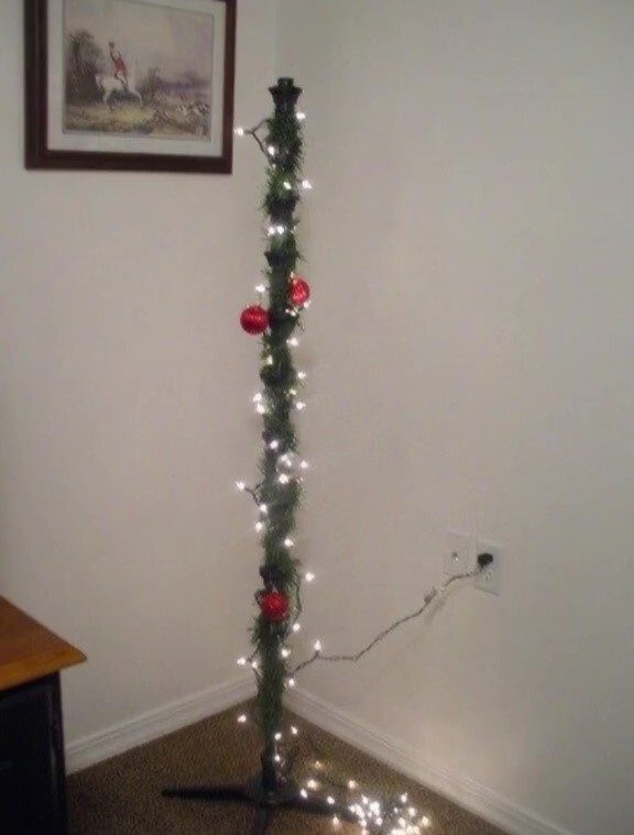 A thin, sparsely decorated Christmas tree stands in a corner.