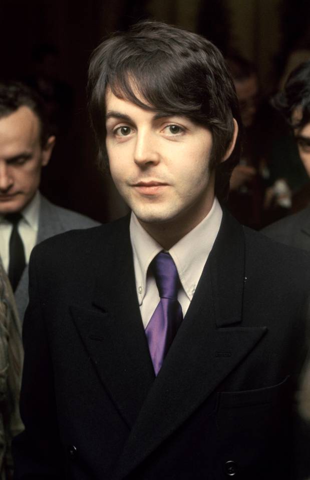 Paul McCartney of the Beatles in a dark suit and purple tie.