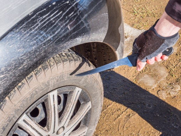 A knife slashing a car tire.