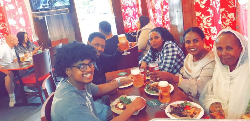 Family enjoying drinks and food at a pub.