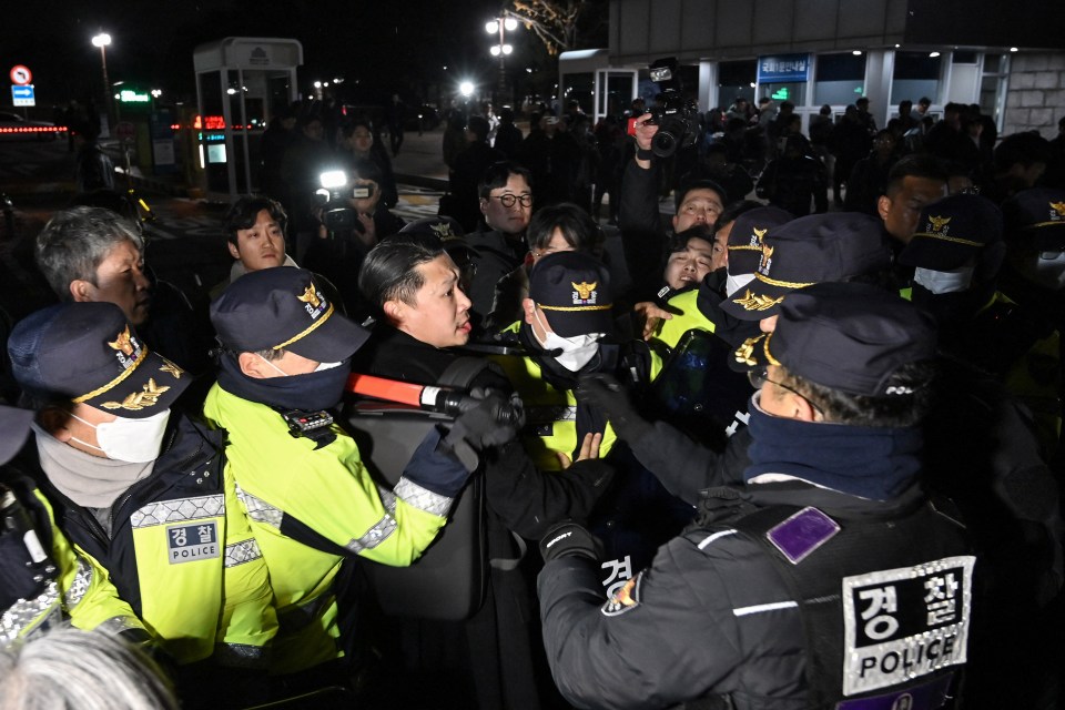 Police attempt to hold back people trying to enter the National Assembly in front of the main gate