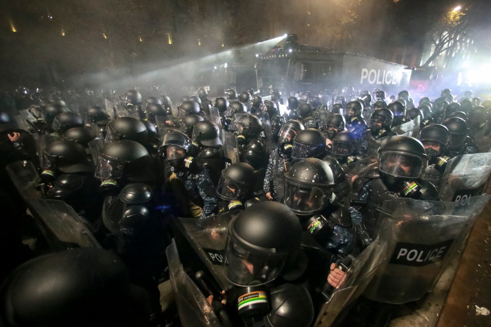 Police use a water cannon on protesters during a rally outside the parliament