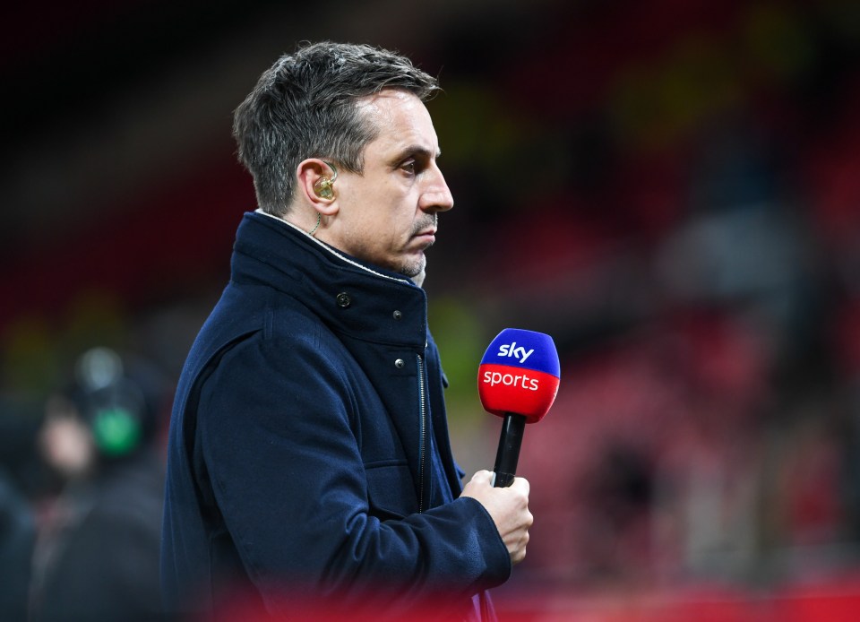 Gary Neville holding a Sky Sports microphone at a Premier League match.