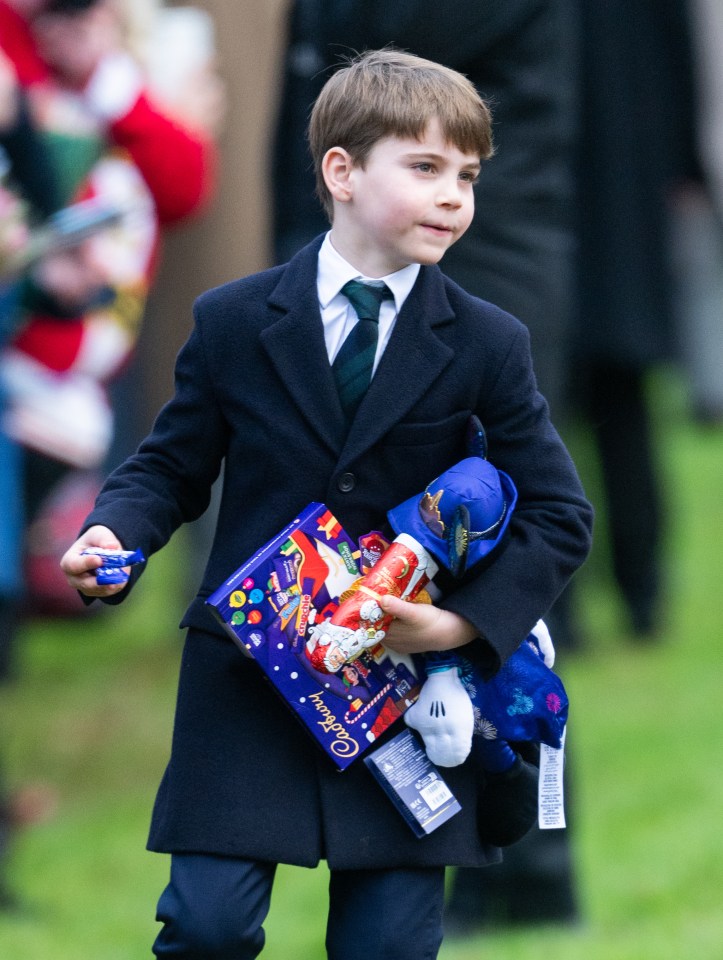 Prince Louis of Wales carrying Christmas gifts after a church service.