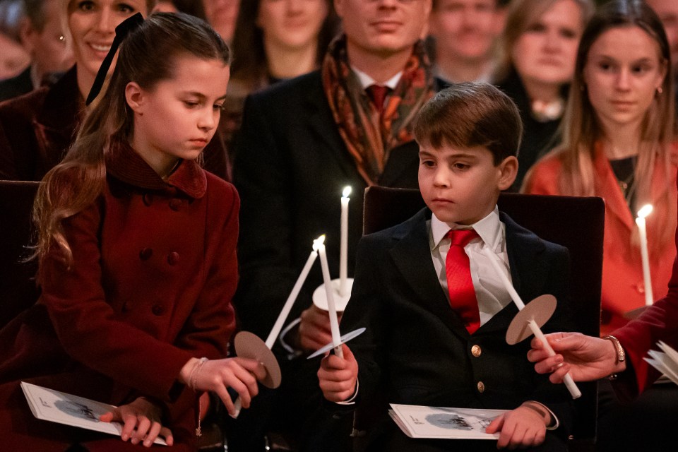 Princess Charlotte and Prince Louis holding candles at a Christmas carol service.