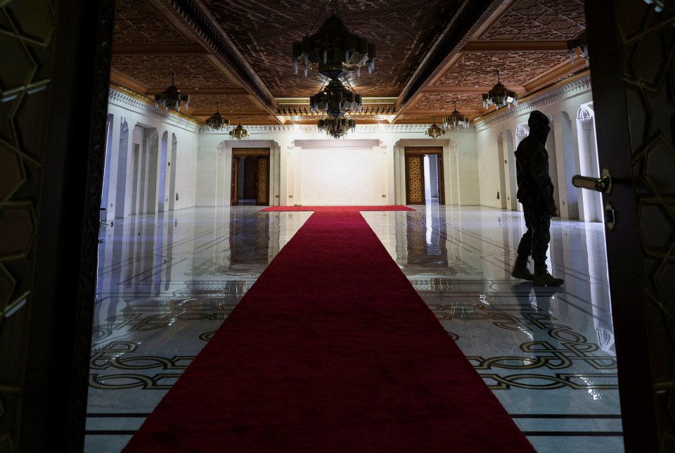 A rebel fighter walks inside the welcoming hall in the Presidential Palace