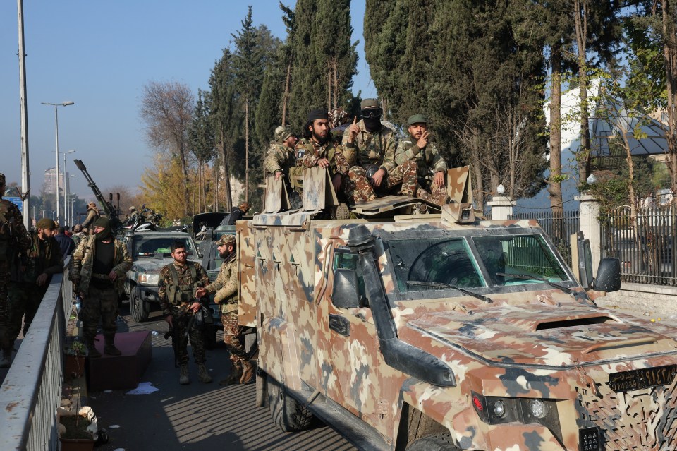 Rebel Syrian fighters in Damascus after taking control from Assad's government