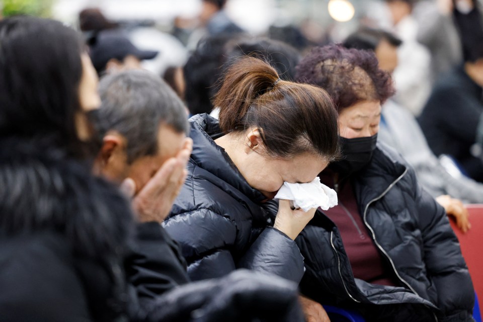 Grieving relatives of plane crash victims at an airport.