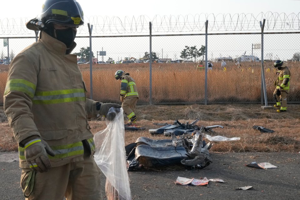 Rescue workers collect debris near the wreckage of a passenger plane.