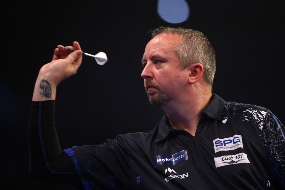 Ritchie Edhouse of England throws a dart during a darts match.