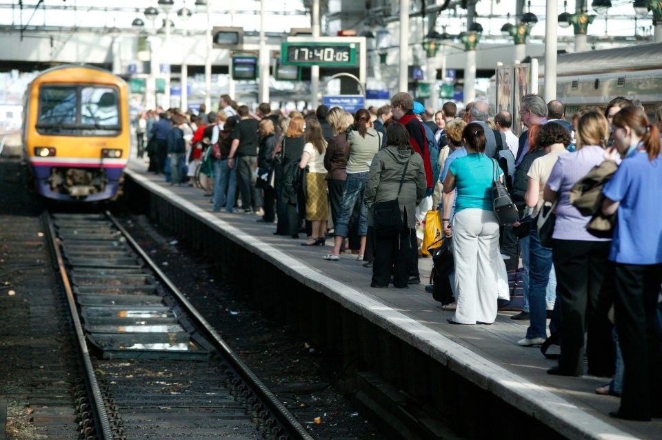 Rush-hour travellers throng the platform at Manchester Piccadilly station as a train approaches