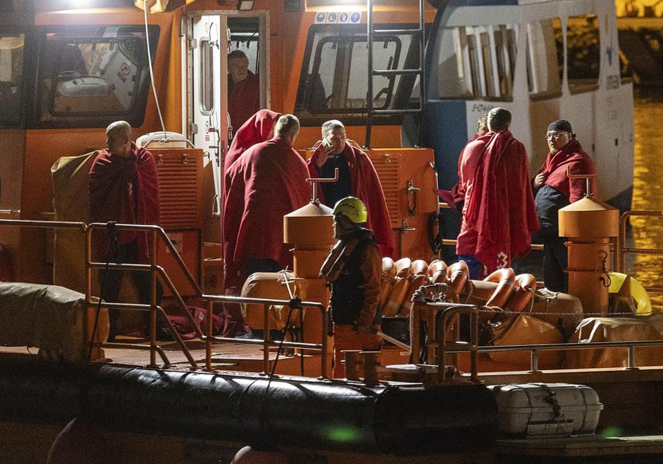 Rescued crew members of the sunken Russian vessel Ursa Major aboard a rescue boat.