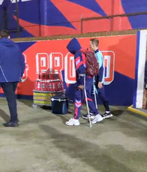 Saka on crutches after a game, assisted by a teammate.