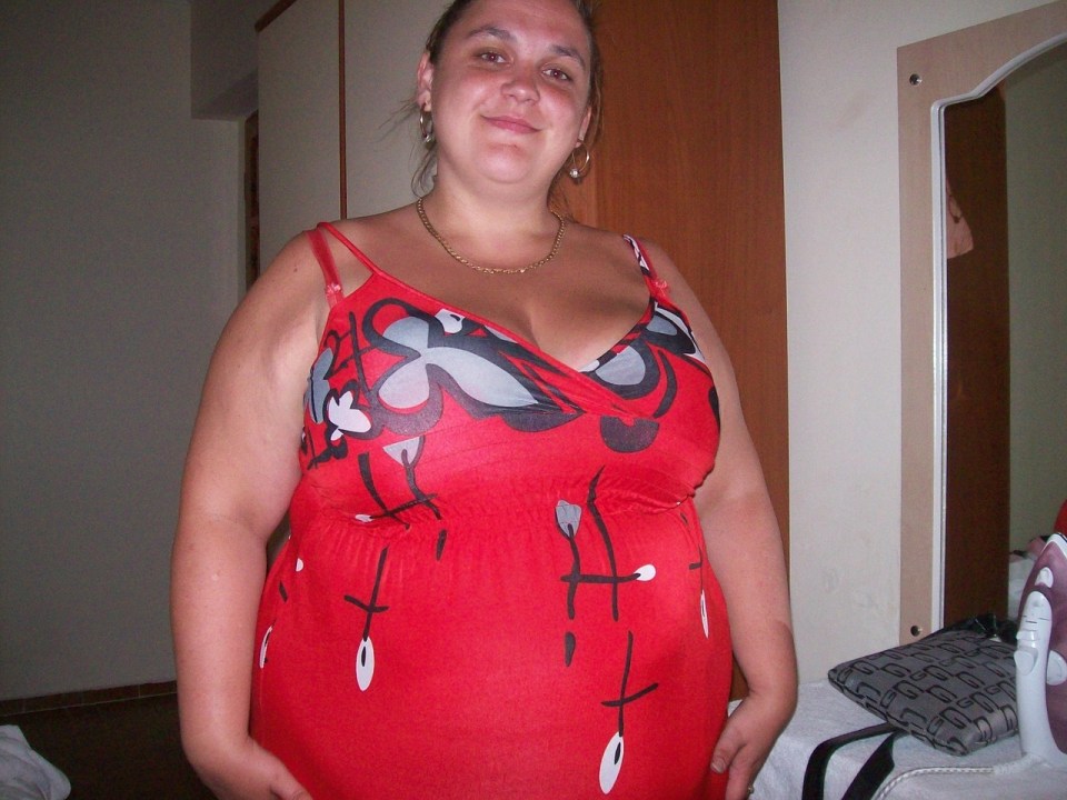 Woman in red dress after significant weight loss.