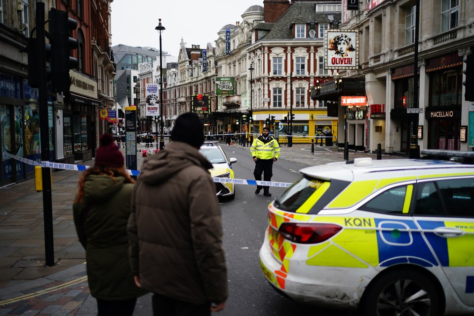 Crime scene on Shaftesbury Avenue in London, with police and onlookers.