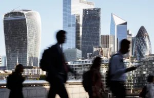 Silhouetted business people walking in front of London's skyline.