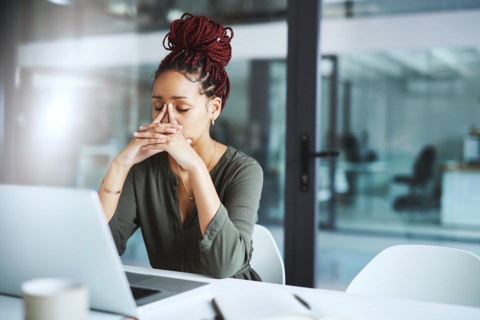 Stressed businesswoman at her laptop.