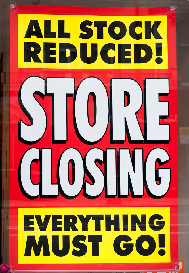 A sign in the window display of a closing shop, advertising clearance prices