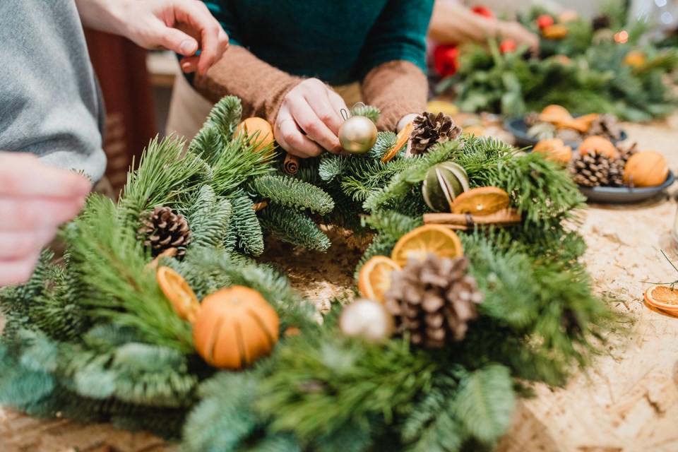 Close up shot of floristsdesigning a christmas wreath.