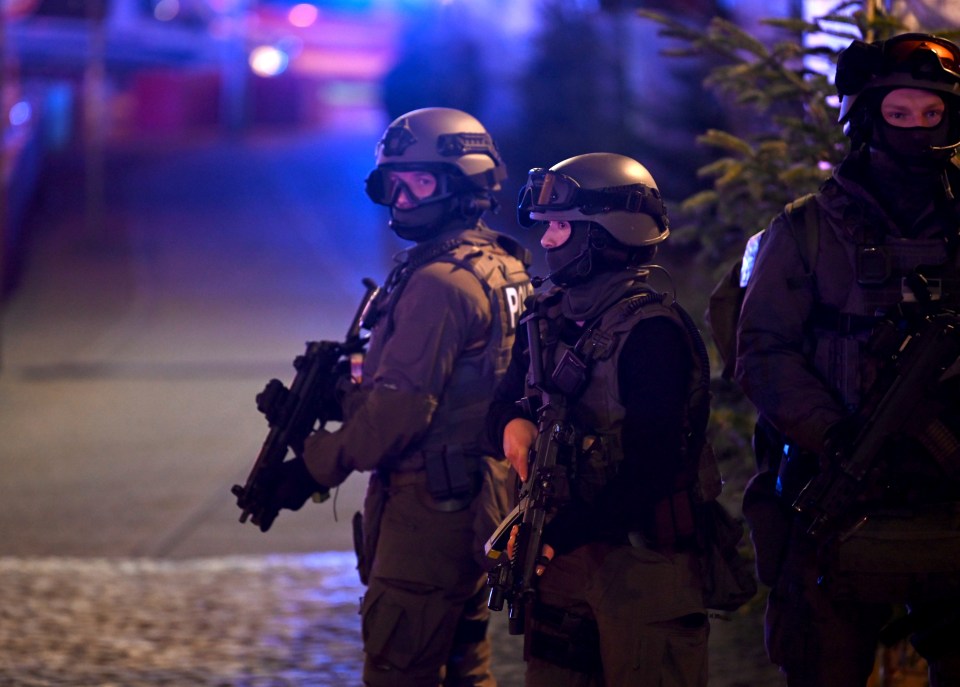 Police officers in tactical gear respond to an incident at a Christmas market.