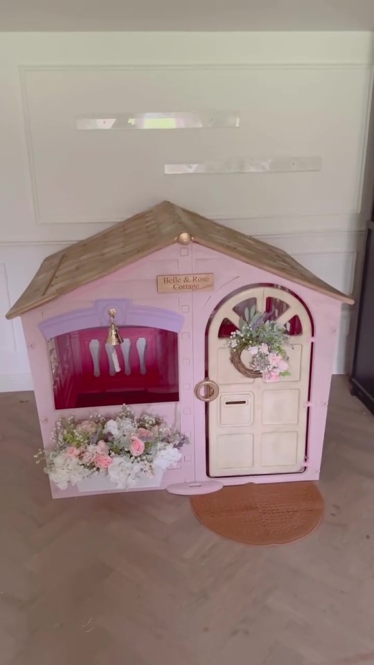 Pink children's playhouse decorated with flowers.