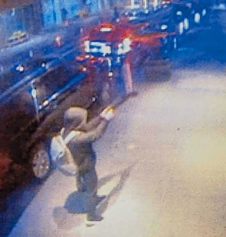 Surveillance image of a person holding a gun near a Starbucks.