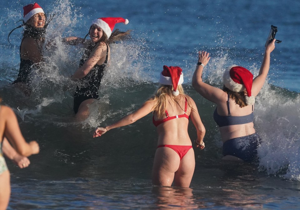 Swimmers in Santa hats participating in a Boxing Day dip.