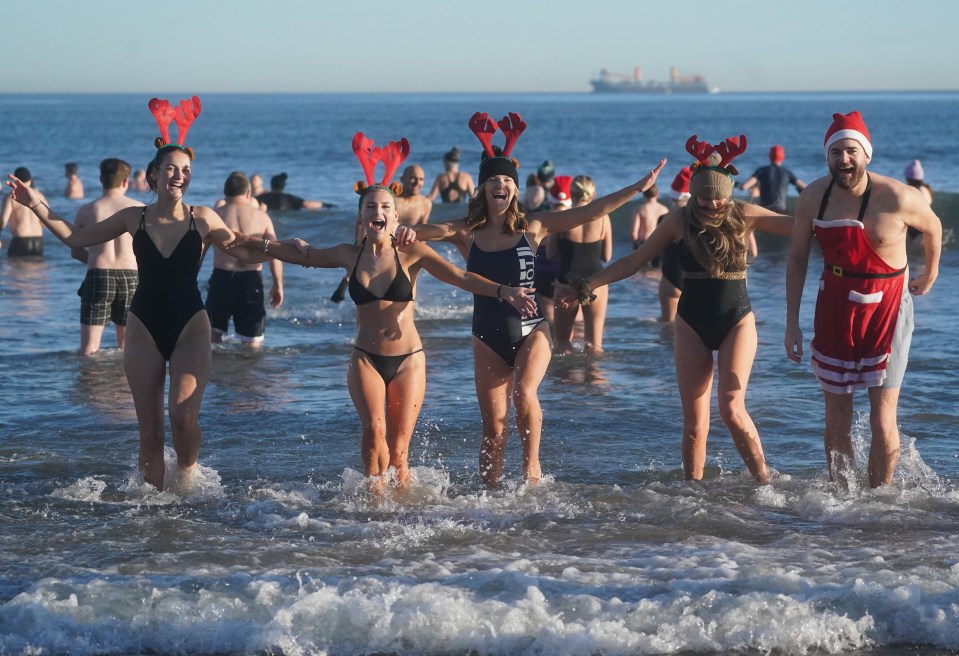 Swimmers in festive attire participate in a Boxing Day dip at Tynemouth beach.