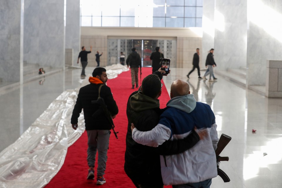 Syrian rebel fighters take a selfie inside the palace