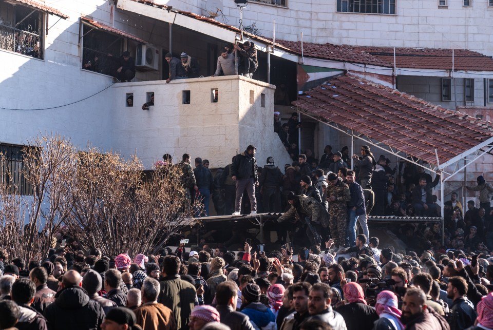 Syrians seen outside Sednaya Prison waiting to see if their family and friends will make it out alive