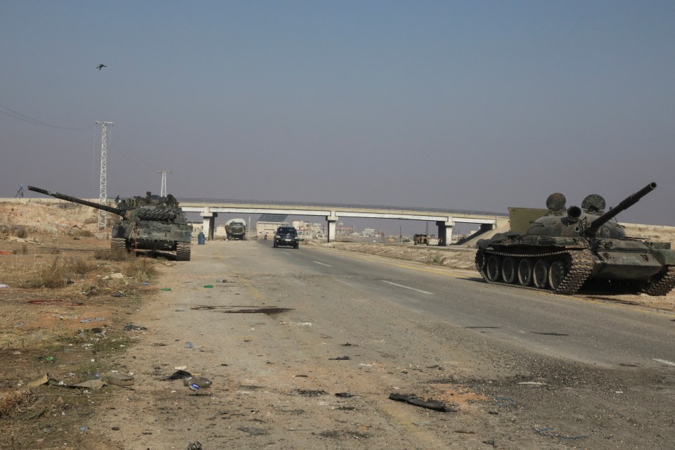 Tanks stand by the side of the road after they were disabled by the Syrian rebels HTS