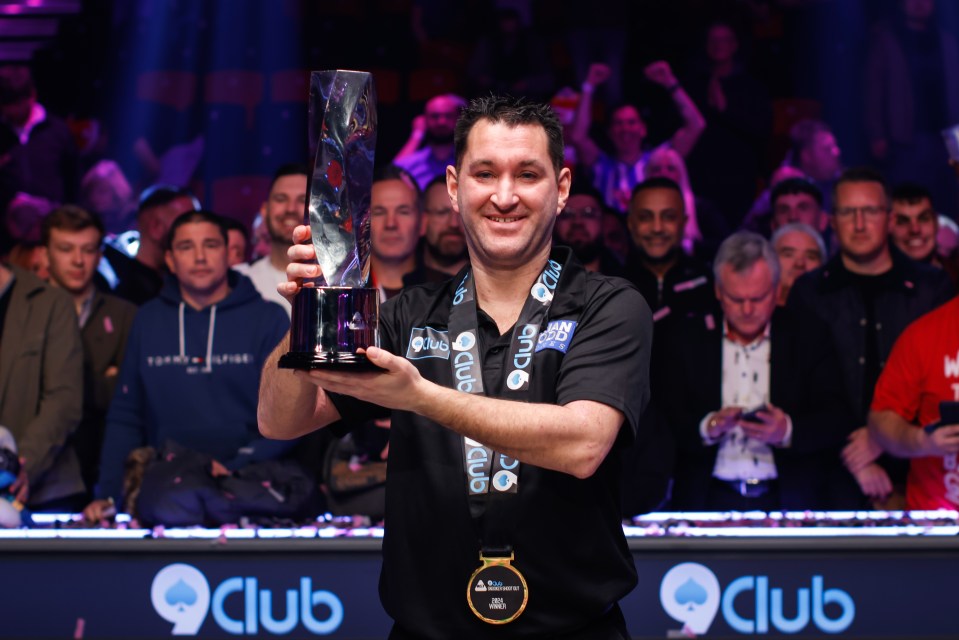 Ford, 41, poses with the trophy following his triumph