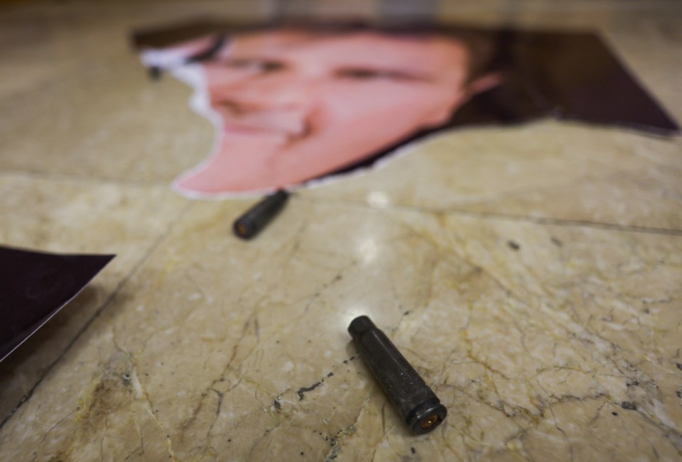 A view of an empty bullet next to a picture of Syria’s Bashar al-Assad at one of the rooms in Presidential Palace