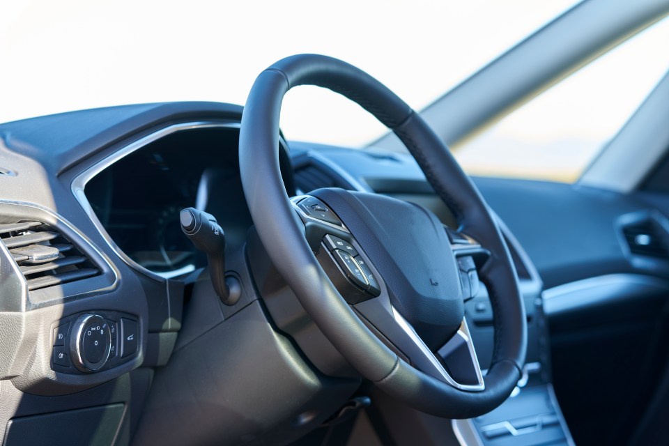 View of steering wheel and control panel vehicle interior at sunlight day