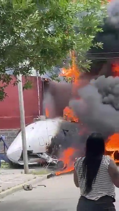 The jet could be seen lying on its side burning after it crashed into the house