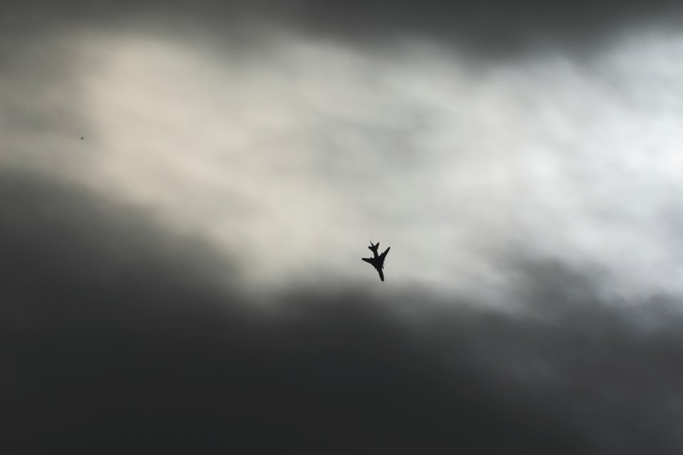 A warplane flies over Homs countryside