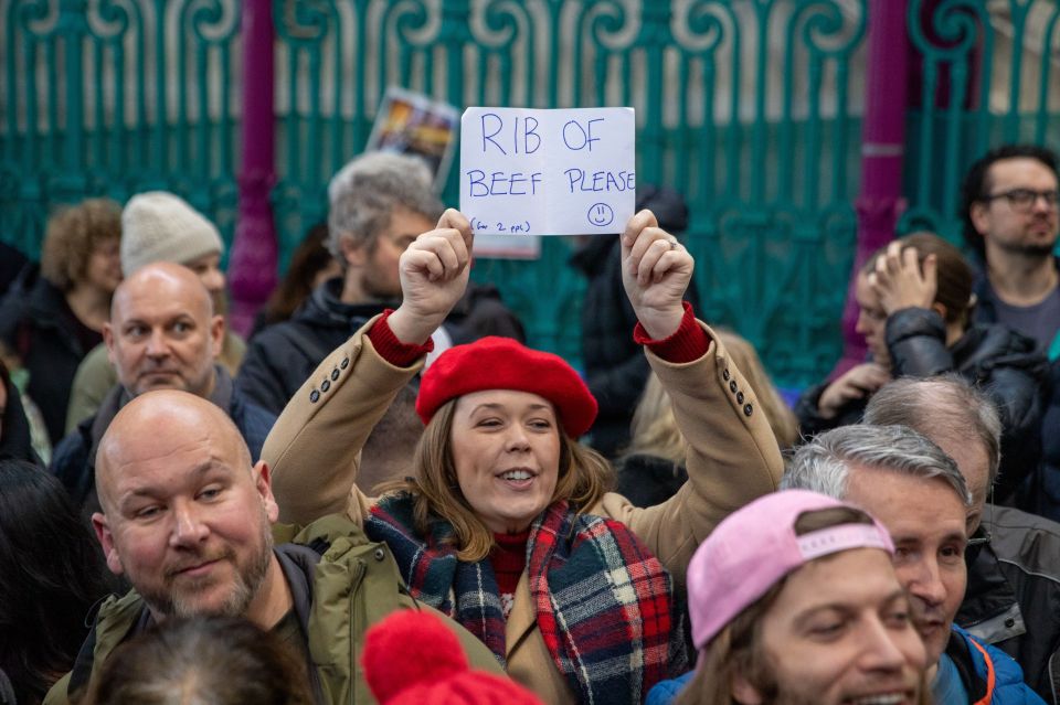 A woman holds up sign asking for a rib of beef