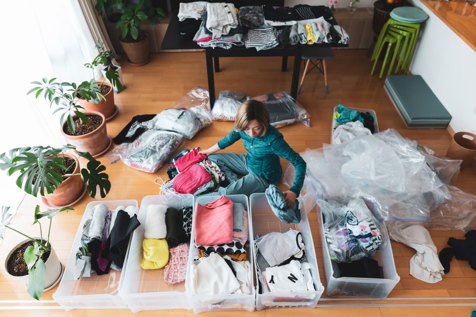 Woman organizing clothes in her living room.