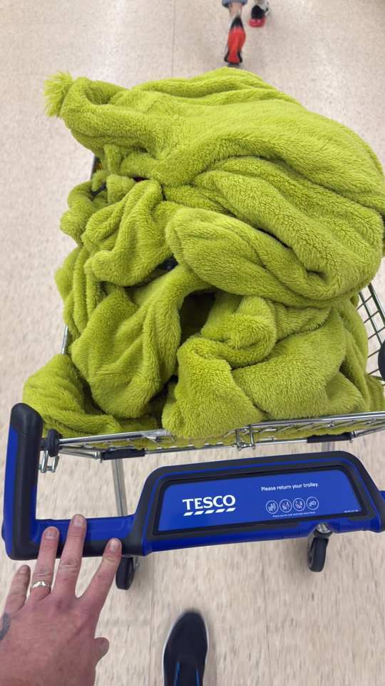 Lime green fleece blanket in a Tesco shopping trolley.