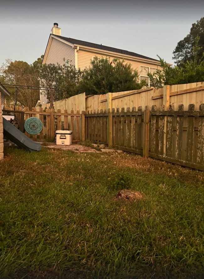 The new fence runs alongside the old fence, leaving both visible to the homeowner