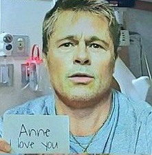 Photo of Brad Pitt holding a note that says "Anne I love you."