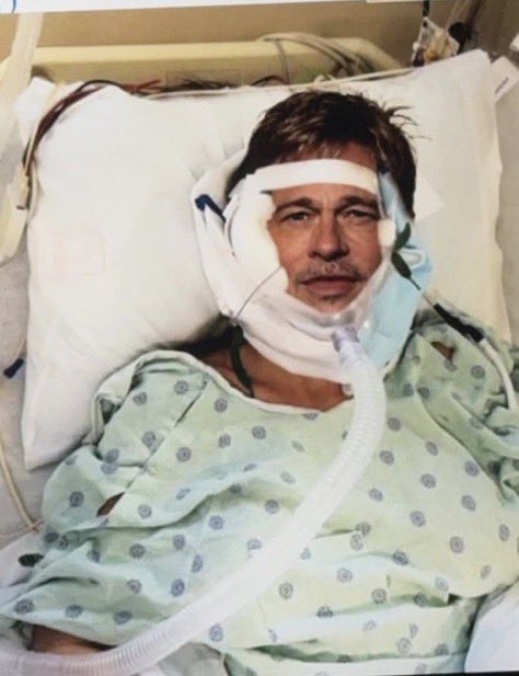 Photo of Brad Pitt in a hospital bed wearing a surgical mask.