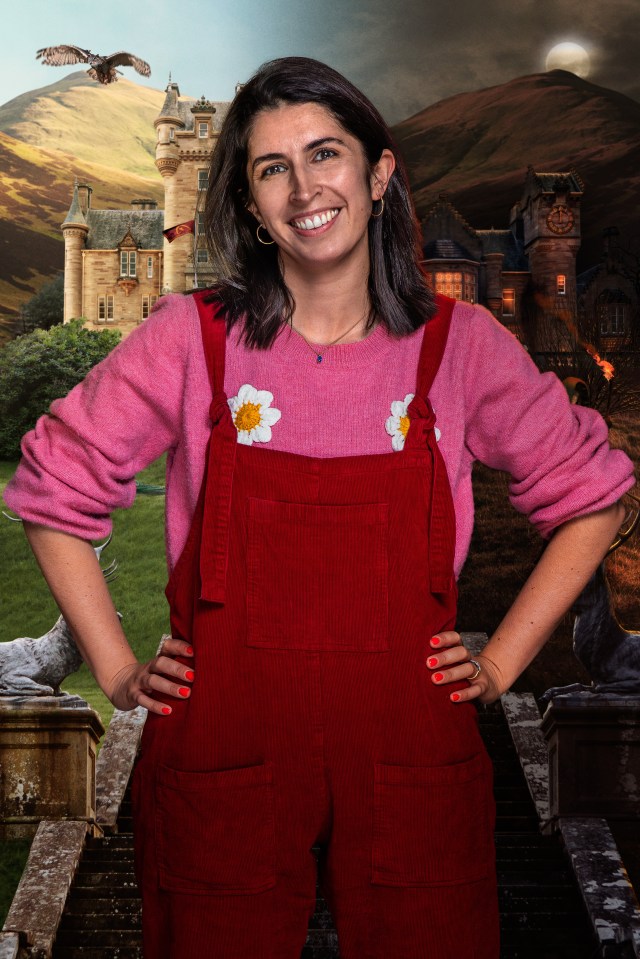 Portrait of a smiling woman in red overalls and a pink sweater, set against a backdrop of two castles.