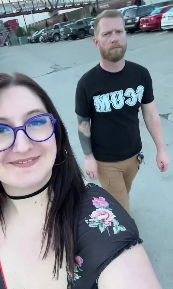 A woman and a man walking in a parking lot.