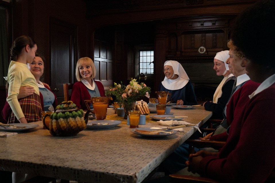 A group of nurses and nuns seated at a table for a meal.